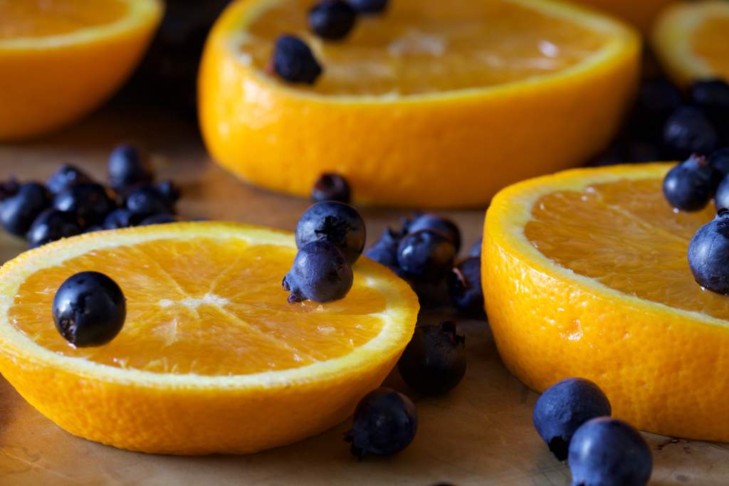 Closeup of fresh oranges slices with blueberries scattered on top