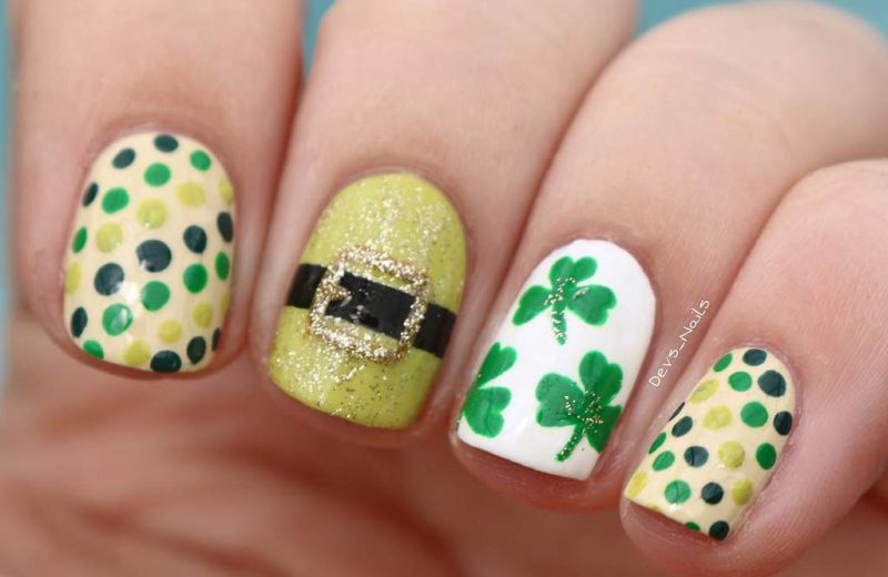 Fingernails with different designs including a leprechaun's hat buckle, green shamrocks and green polka dots.